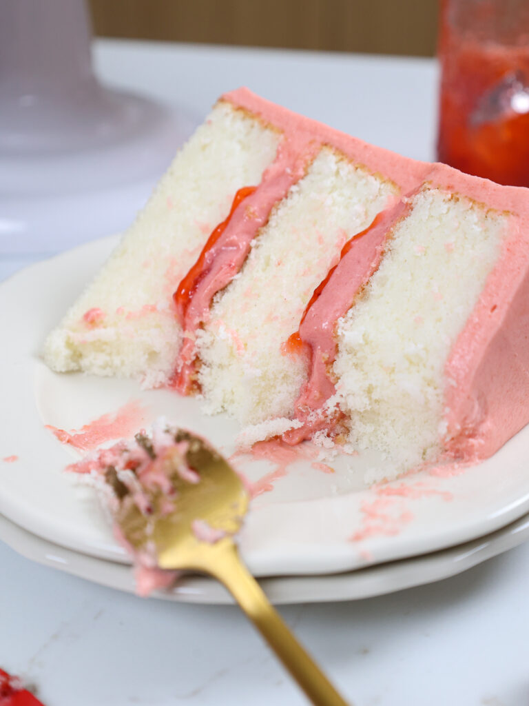 image of a slice of strawberry mousse cake that's been cut into to show how delicious it is