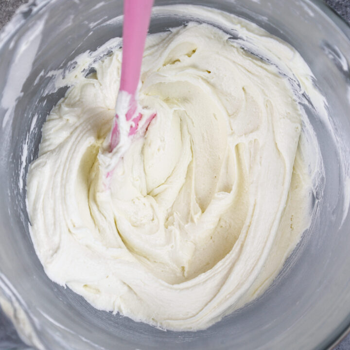 image of vanilla american buttercream in bowl that's been stirred with a spatula to make it super smooth