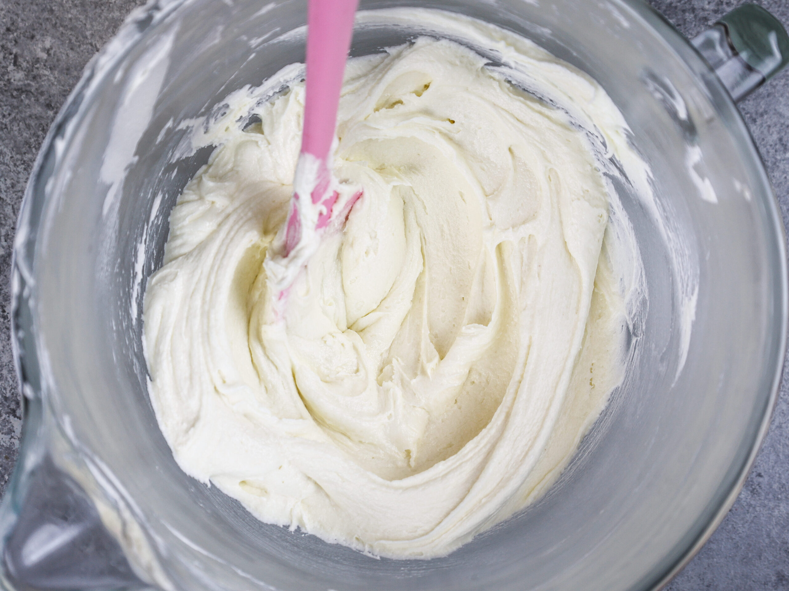 image of white frosting in bowl that's been stirred with a spatula to make it super smooth