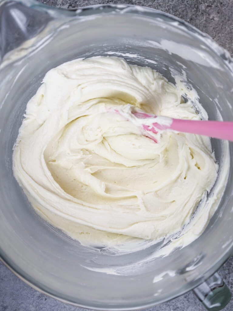 image of vanilla american buttercream in bowl that's been stirred with a spatula to make it super smooth