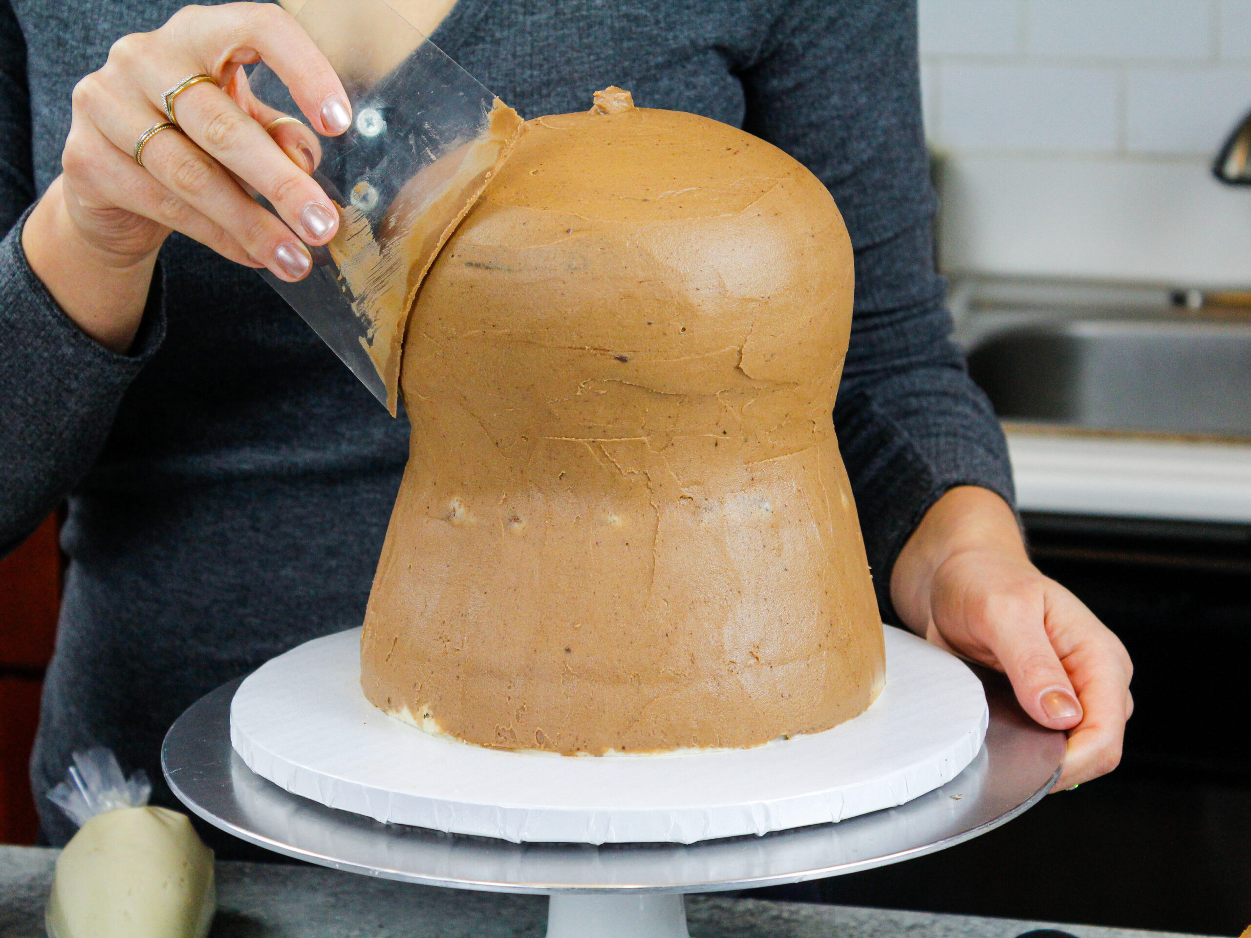 image of a cake being crumb coated with chocolate peanut butter frosting
