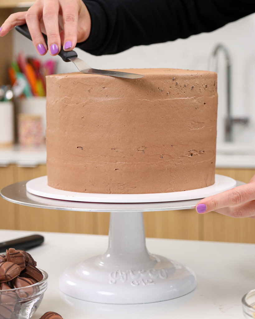 image of a kinder bueno cake being crumb coated with Nutella buttercream