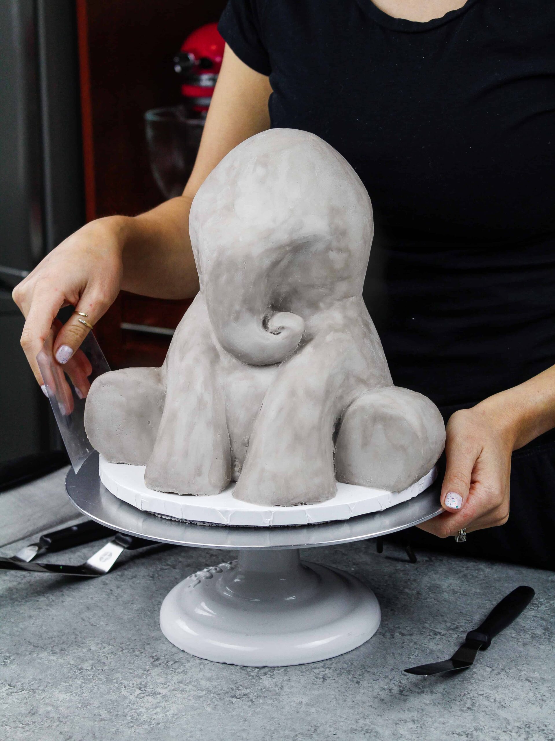 image of an elephant cake being frosted with naturally grey buttercream frosting