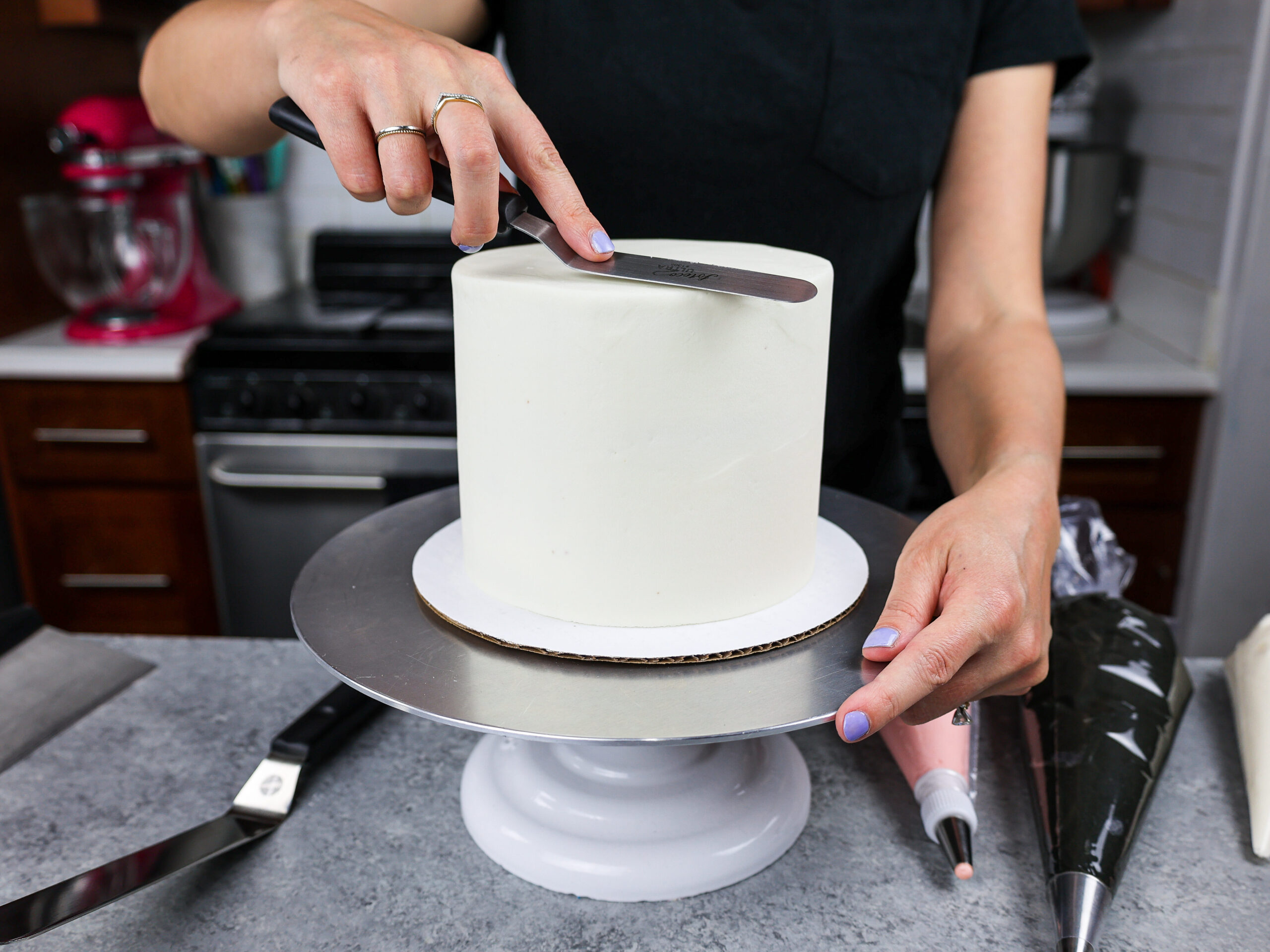 image a 6-inch layer cake that has perfectly smooth white buttercream frosting