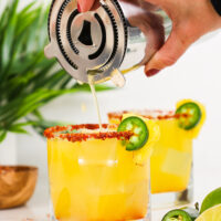 image of spicy pineapple margarita being poured into a glass