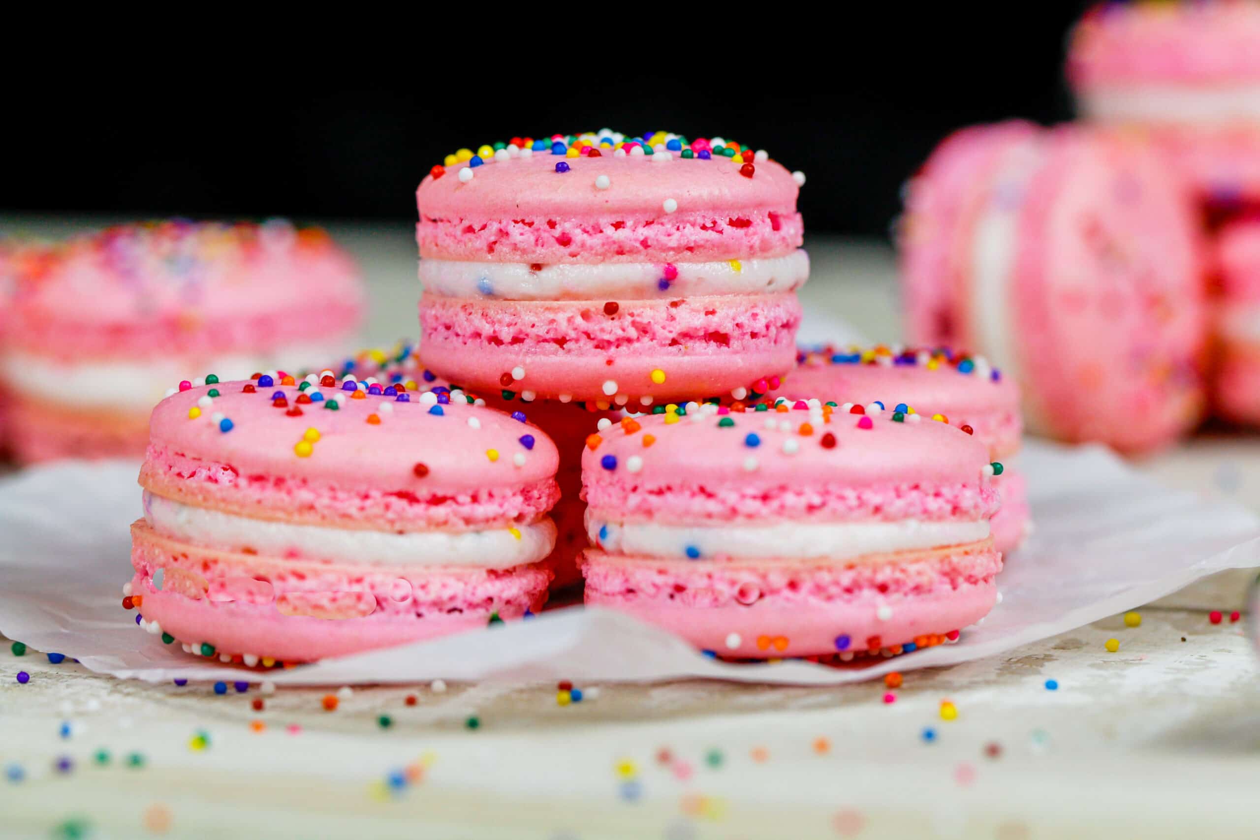 image of birthday cake macarons stacked on a plate