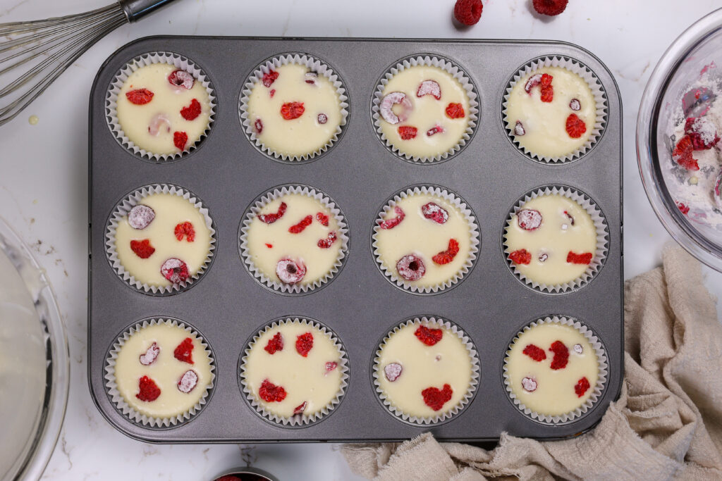 image of raspberry cupcake batter studded with fresh raspberries tossed in flour that're ready to be baked