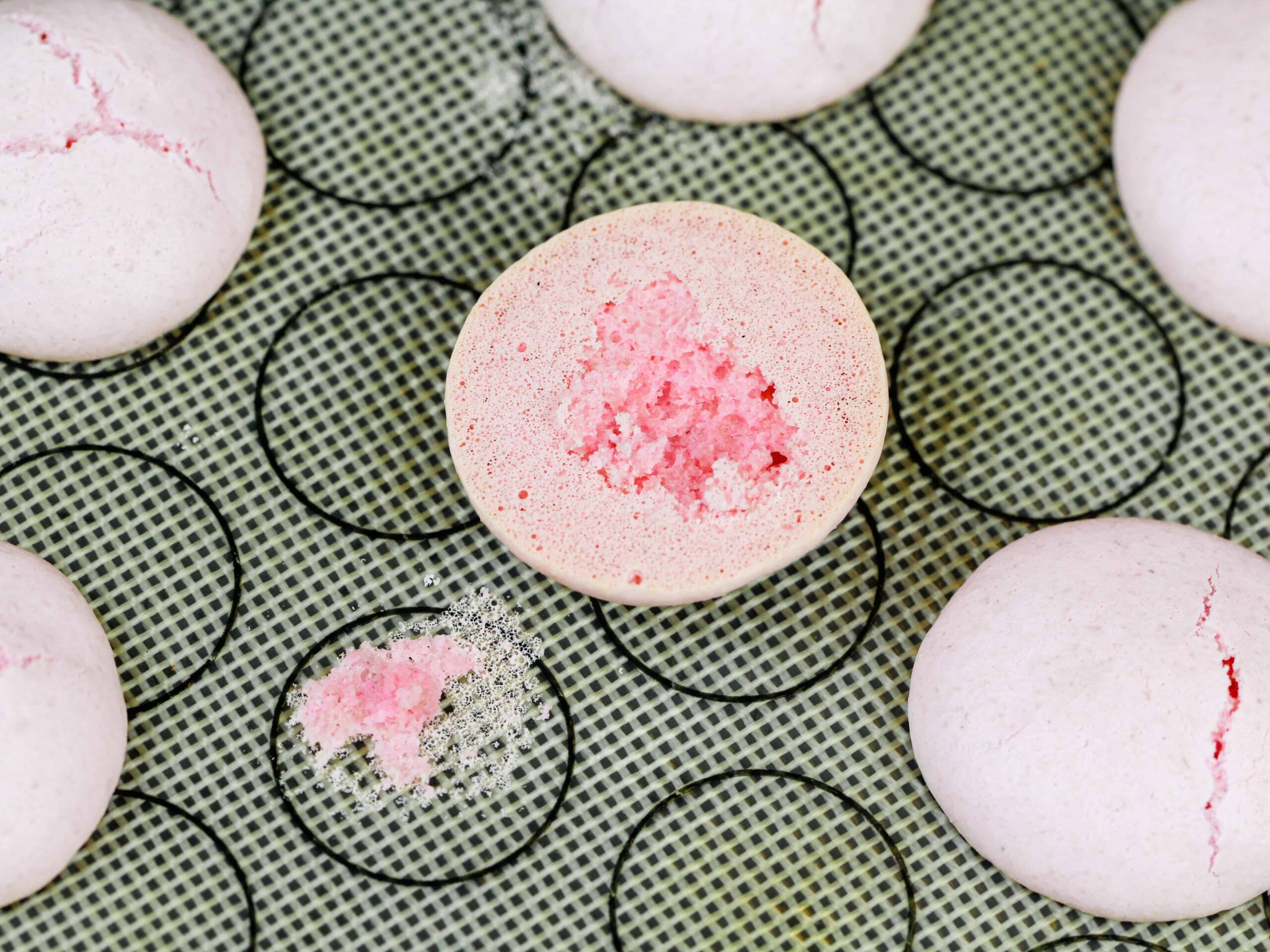image of macarons that stuck to the tray included in a macaron troubleshooting guide explaining how to avoid this issue
