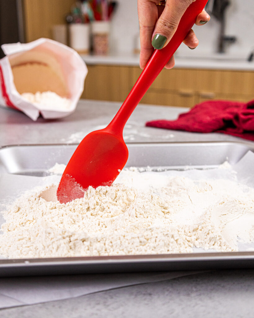 image of heat treated flour being stirred to make sure it heats evenly while in the oven