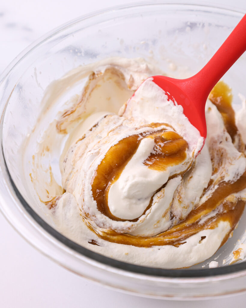 image of hazelnut white chocolate ganache being folded into whipped cream to make a hazelnut mousse