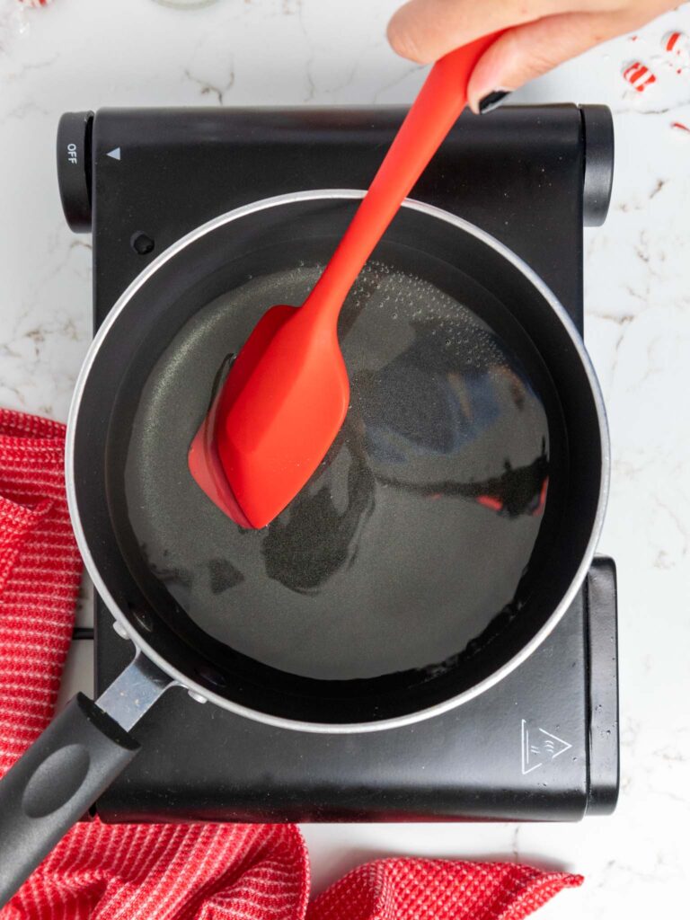 image of peppermint simple syrup being cooked and stirred in a saucepan