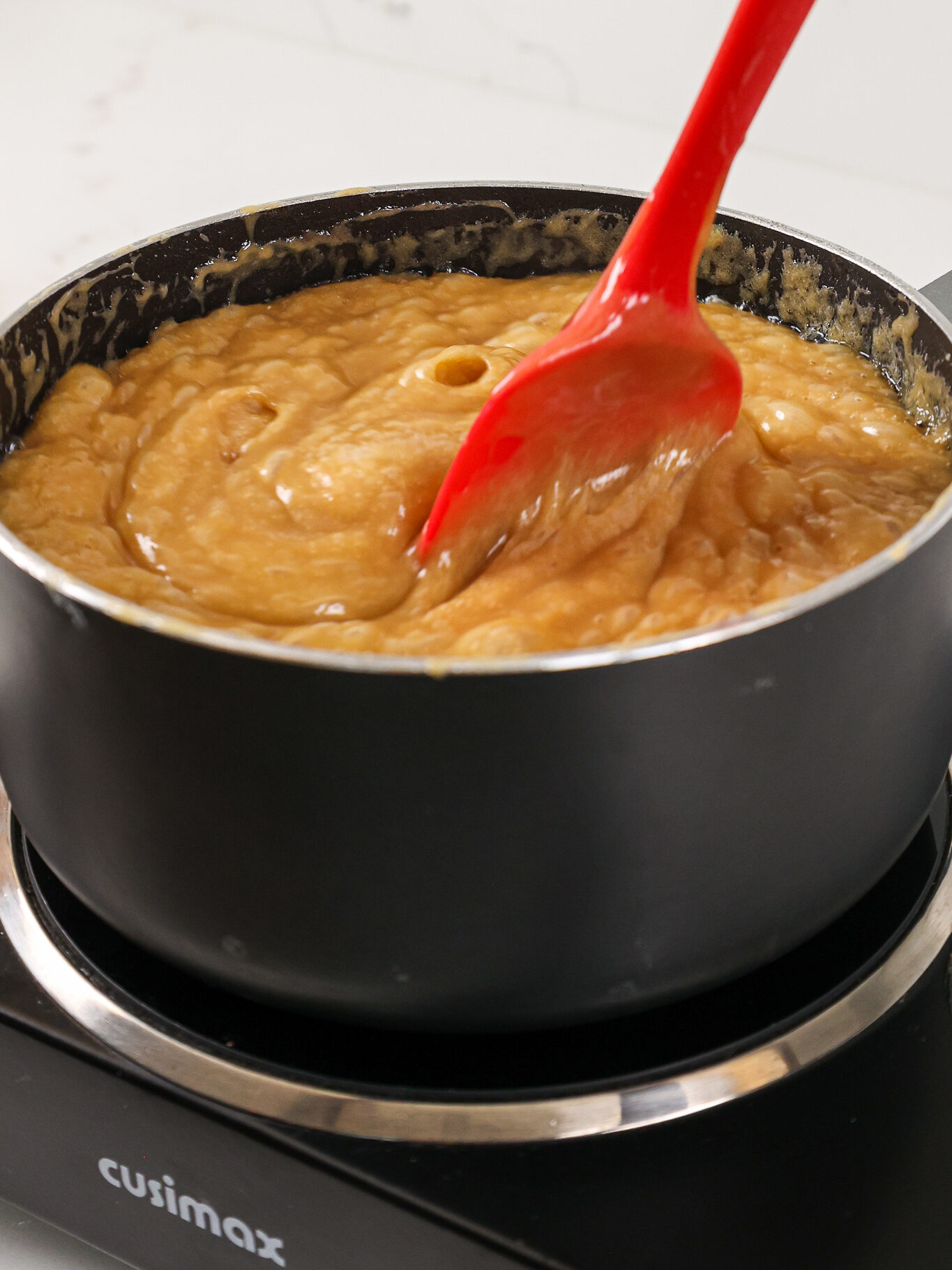 image of thick caramel filling being cooked until it reaches 230 degrees Fahrenheit