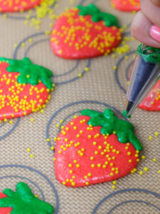 image of strawberry macaron shells being piped