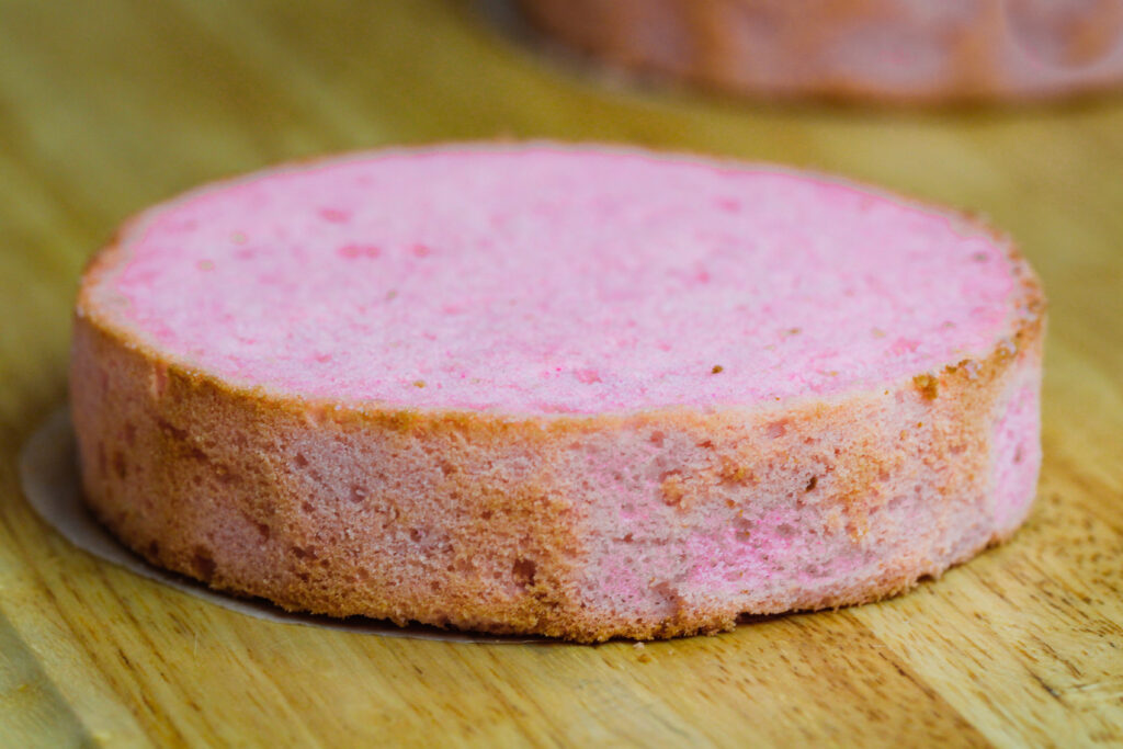 image of pink cake layer that has been trimmed and leveled to make a pig cake