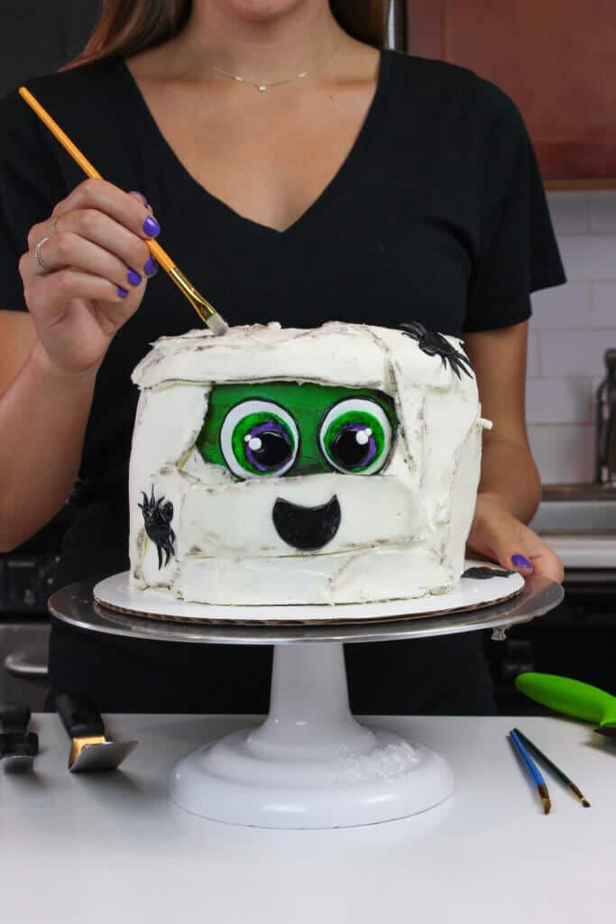 image of brushing cocoa onto mummy cake to make it look older