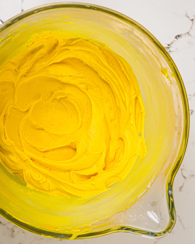 image of golden yellow buttercream in a mixing bowl